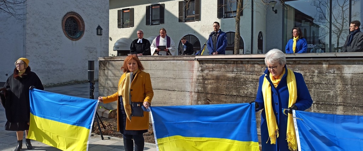 Hinter den von den CSU-Vertreterinnen Prof. Ursula Mnnle, Ute Nicolaisen-Mrz und Stefanie von Winning zum Zeichen der Verbundenheit gezeigten Nationalfarben der Ukraine die Akteure des Starnberger Friedensgebets (v.l.) Pfarrer Johannes de Fallois, Pfa